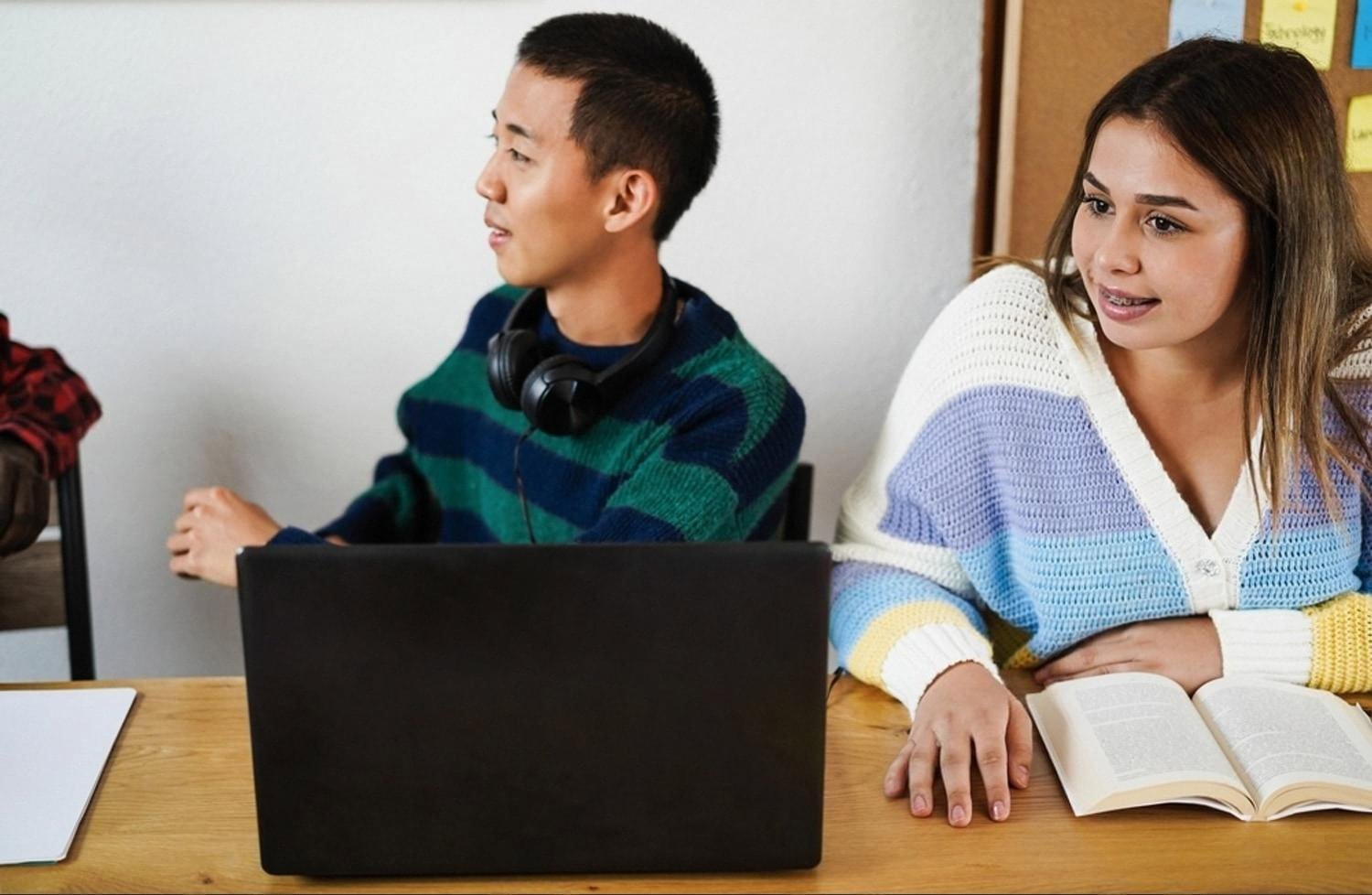 Two junior doctors reviewing MRCP question bank material on a laptop