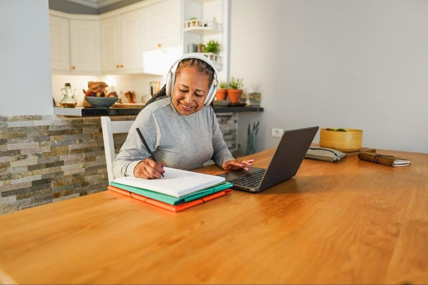 Doctor studying MRCP notes at home with laptop and headphones